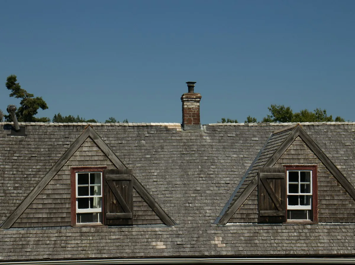 Roof Replacement in Sherman — a slate roof with dormers and a chimney on an older house